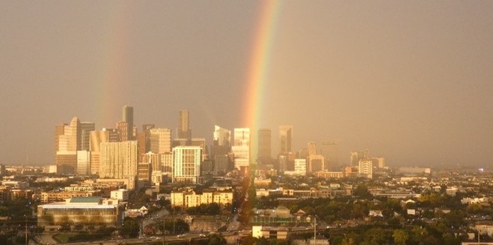 A photo of the Houston skyline, featuring a double rainbow.