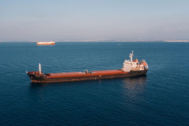 Aerial view of a cargo ship sailing in the open sea under clear skies