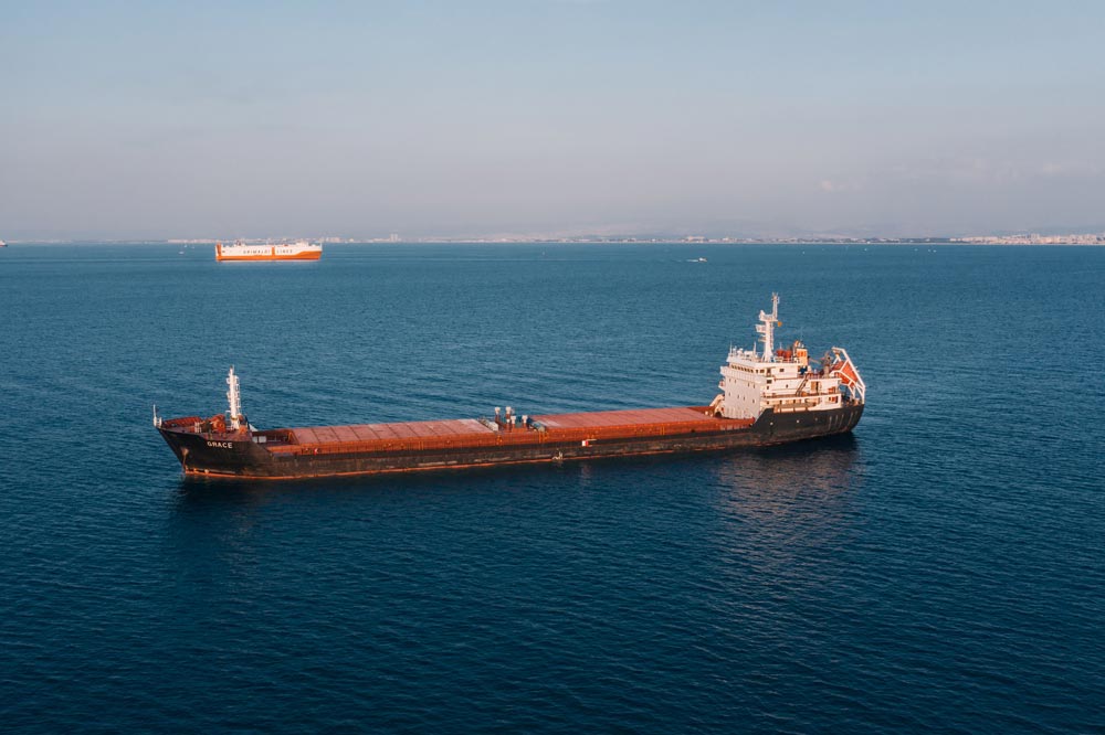 Aerial view of a cargo ship sailing in the open sea under clear skies